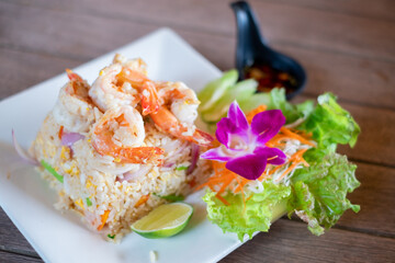Fried rice with shrimp on the white dish on wooden table, Thai Food