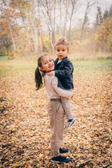 Fototapeta premium Brother and sister playing in the forest and smiling 