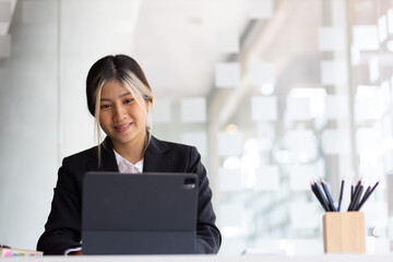 Asian businesswoman working with modern tablet in office.