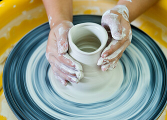Young boy making a pitcher of clay