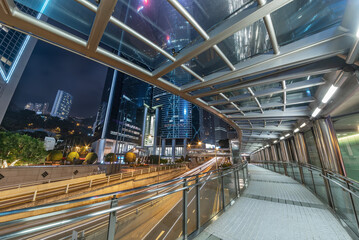 Night scenery of modern pedestrian walkway in downtown district of Hong Kong city