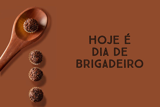 Brigadeiro (Brigadeiro) Traditional Brazilian sweet. Chocolate sweets on dark background written in portuguese "today is brigadeiro day"