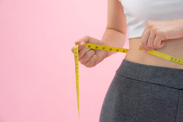 Diet and dieting. Beauty slim female body use tape measure. Woman in exercise clothes achieves...