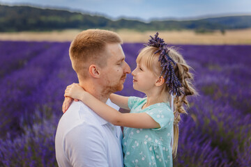 father and daughter look at each other. a happy father holds a child in his arms