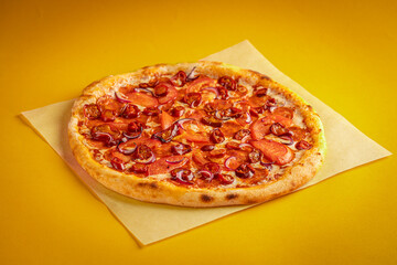 Fresh classic pizza with tomato sauce, mozzarella, spicy chorizo, bell pepper on a yellow background