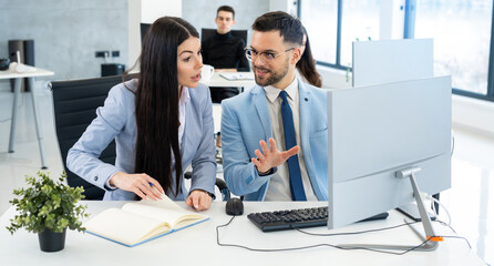 Two businesspeople collaborate closely, engaging in a discussion about a project while emphasizing...