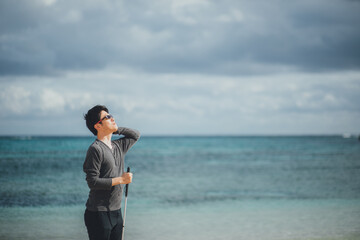 視覚障害者の男性が沖縄の海で解放感を感じている