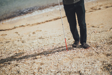 白杖を持った視覚障害者の男性が沖縄で旅をしている