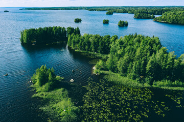 Aerial view of blue lake with islands and green woods in Finland