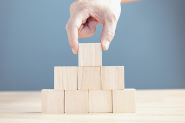 hand of a businessman stacking wood empty eight blocks with copy space for text or symbols, development concept for growth success process.