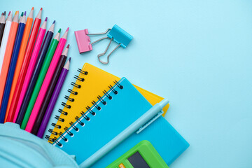 Opened School backpack with stationery on blue background. Organization of the school space. Concept back to school. School supplies.