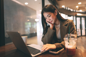 Happy business freelance asian woman using laptop computer at cafe urban lifestyle