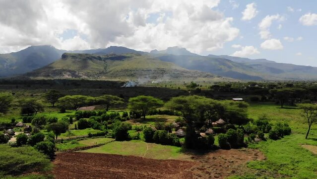 Aerial view of typical african villages called manyattas with mountains in the background in a sunny day, Karamoja, Uganda, Africa