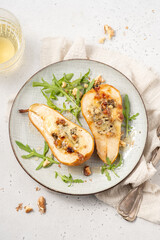 Pear baked with blue cheese, honey and walnuts with arugula salad