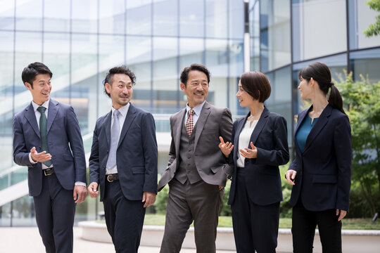 Image of a business scene with a team of cool businessmen wearing suits with a range and diversity of ages and genders.