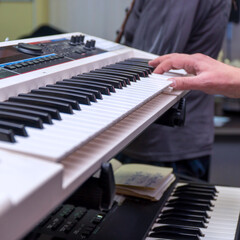 Fototapeta na wymiar A pianist or keyboardist plays a synthesizer