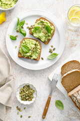 Avocado sandwich with pumpkin seeds. Healthy vegetarian avocado toast with rye bread for breakfast. Vegan menu