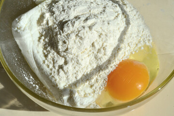 there is flour, cheese and egg in a transparent plate
