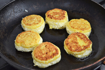 Ready fried cheesecakes lie on the pan
