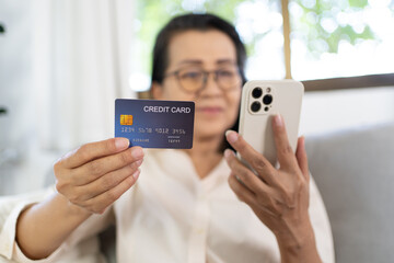 Senior woman with smart phone for online shopping.  Hand holding mobile phone with Payment on credit card online shopping electronic wallet Payment Shopping by phone and connected card concept
