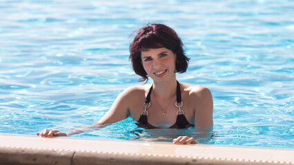 Beautiful adult woman bathes pool on her day off.