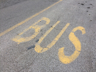 Bus stop. Yellow word bus writing on asphalt on a street.