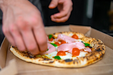 Obraz na płótnie Canvas man chef hand cooking napolitana pizza with mortadella and cheese 