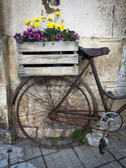 Fototapeta na wymiar An old rusty bike with a box and flowers in it.