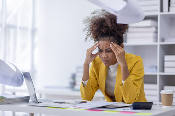 Portrait of tired business african american woman work with documents tax laptop computer in...