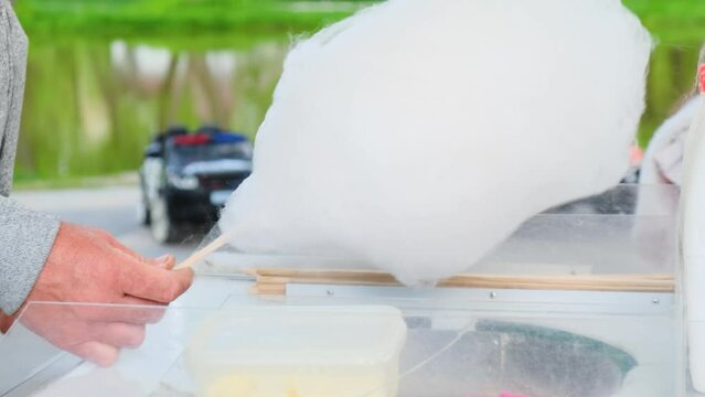 The process of making cotton candy outdoors for children. Close-up.
