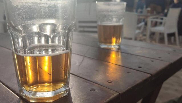 2 vasos de cerveza sobre mesa de madera