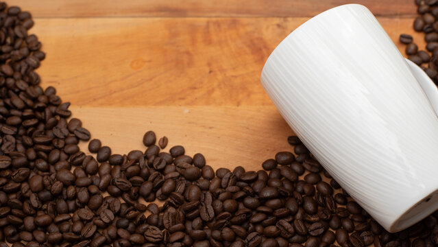 White Mug with Coffee Beans on the side on a Wood Board