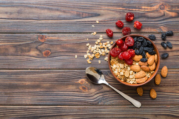 Cooking a wholesome breakfast. Granola with Various dried fruits and nuts in a bowl. The concept of a healthy dessert. Flat lay, top view with copy space