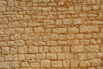 horizontal texture of an old wall made of rubble stone, brown sandstone and old plaster