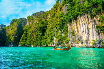 Obraz premium View of Pi Leh lagoon (also known as Green Lagoon) at Ko Phi Phi islands, Thailand. View from typical long tailed boat. Typical Thai picture of tropical paradise. Limestone rock and turquoise water.