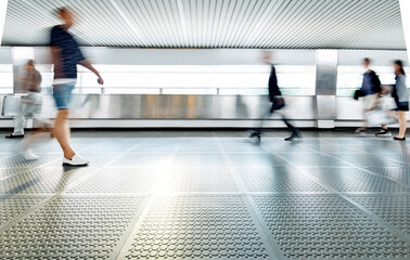 Blurred commuters walking on footbridge