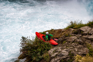 Kayaker for launching into mountain river rapids