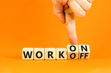 Work on or off symbol. Businessman turns wooden cubes and changes word Work off to Work on. Beautiful orange table orange background. Business and work on or off concept. Copy space.