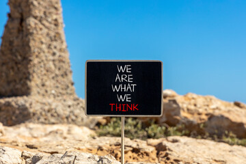 We are what we think symbol. Concept word We are what we think on beautiful black chalkboard. Beautiful stone blue sky background. Business We are what we think concept. Copy space.