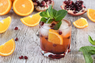 The cocktail is made from pomegranate and orange juice with tequila or gin, with the addition of tonic. Served in a glass with ice, orange slices with pomegranate and a sprig of mint. Cocktail recipe 