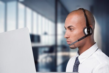 Technical support worker with a headset in modern office.