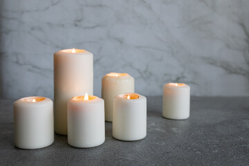 Fototapeta na wymiar White candles on a gray background