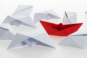 Red paper boat and a lot of sinking ships