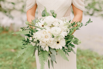 Obraz na płótnie Canvas Bride in wedding dress holding a bouquet