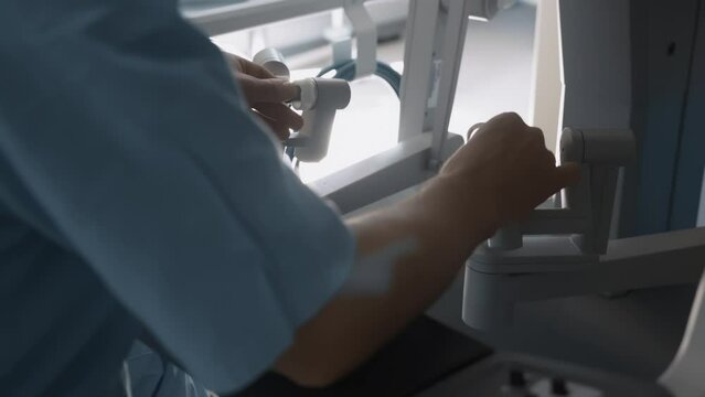 Hands of doctor using advanced robotic surgical system in operating room. Modern methods of invasive surgery, Surgeon arms remotely control precision instruments