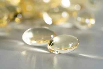 Fish Oil Omega 3 on white background, vitamin D yellow supplement gel capsules, macro shot	
