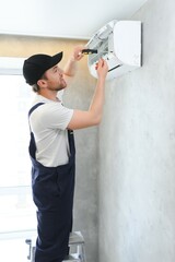 Service man is cleaning, repair and maintenance of air conditioner.