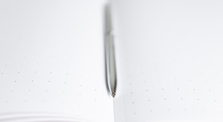 notebook and pen close up with a blurred background in the foreground	