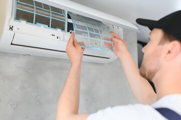 Service man is cleaning, repair and maintenance of air conditioner.