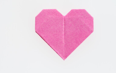 Pink origami heart on white background
